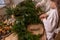 Close-up of faceless young mother with little daughter together making Christmas wreath from spruce