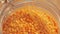 Close-up of falling down red lentils into glass jar. Top view