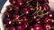 Close up of fast rotation bowl with red cherries on the table.