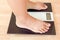 Close up of fat female feet standing on weight scale