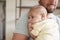 Close Up Of Father Comforting Newborn Baby Son In Nursery