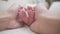 Close up father parent hand touching small feet of baby infant when sleeping on soft bed. footprint details.  care, love, and prot