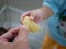 Close up of father`s hand giving a piece of cookie to his baby`s hand