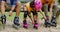 Close up on the feet of an active fun family in a park tying or putting on the rollerblade inline. A mother, father, and