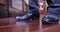 Close-up feet and black men`s shoes. A young man in a suit walks over to a panoramic window and enjoys the view of the