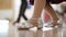 Close-up feet of Caucasian girl in silver high-heels making ballet step in slow motion. Unrecognizable children