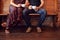 Close Up On Feet Of Couple Sitting On Bench In Coffee Shop Together