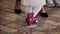 Close-up feet of little girl in red sandals walk on concrete paving slabs