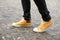 Close up Feet of man while walking commuting to work. Male in yellow sneakers being walking down the street. Confident man Feet Wa