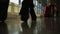 Close-up of the feet of passengers pass through the corridor of the airport and wheeling suitcases.