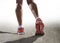 Close up feet with running shoes and female strong athletic legs of sport woman jogging