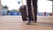 Close up of feet of successful businessman walking near terminal and pulling suitcase on wheels. Legs of young male