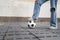 Close up on feet of unknown caucasian female controlling the soccer football ball on the concrete pavement copy space