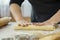 Close up female baker kneading yeast dough on table sprinkled with flour