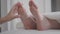 Close-up of female Caucasian feet heated with moxa. Indirect moxibustion of unrecognizable young woman. Acupuncturist