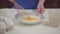 Close-up of female Caucasian hands mixing flour with eggs. Mother or grandmother baking at home. Hobby, leisure activity