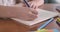 Close-up of female Caucasian hands solving math problem in the exercise book. Elementary student doing lessons