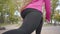 Close-up of female Caucasian legs doing walking lunges. Young sportswoman training in the autumn park in the morning