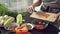 Close-up female cook hands chopping pepper for salad on a wooden board in the kitchen. Healthy eating