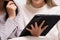 Close up.Female Couple using digital tablet shopping online and researching online on tablet while sitting on sofa