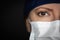Close-up Female Doctor or Nurse Wearing Medical Face Mask on Dark Background
