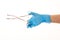 Close up of female doctor\'s hand in blue sterilized surgical glove with forceps against white