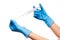 Close up of female doctor\'s hands in blue sterilized surgical gloves with plastic medical syringe against white