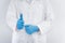 Close-Up Female Doctor`s Hands is Thumbs Up and Wearing Blue Glove in Medicine Uniform Against Isolate White Background.