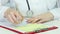Close-up of female doctor\'s hands writing prescription and giving it to patient