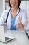 Close up of female doctor thumbs up. Happy cheerful smiling brunette physician ready to examine patient. Medicine