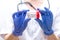 Close up. Female doctor in white coat and gloves holds container for collecting urine. White background. Timely medical