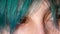 Close-up of female eyes. Green hair in front of eyes