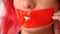Close-up female face. Red tape sealed mouth. Woman with her lips covered by a tape.
