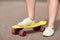 Close up of female feet riding short skateboard