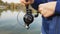 Close-up of a female fisherman with a rod spinning a spinning reel. Fishing in a pond with a line pulling