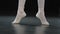 Close-up female foot in pointe shoes tying laces rise standing on floor in dance class stage performance. Unrecognizable