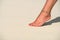 Close-up of female foot in the sand on the tropical beach. Vacation holidays