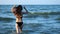 CLOSE UP: Female or girl feet step on yellow sand from seashells, go into the sea. The girl plunges into the water