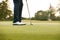 Close Up Of Female Golfer Putting Ball On Green