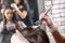 Close up of female hairdresser`s hands are dyeing client`s hair
