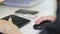 Close-up of female hand on black mouse. Woman`s hand using cordless mouse on white table. Close up portrait of the hands