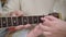 Close-up of female hand on guitar fingerboard. Unrecognizable Caucasian husband teaching wife playing musical instrument