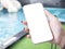 Close up of female hand holding phone at swimming pool with isolated screen