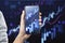 Close up of female hand holding tablet with glowing growing forex chart on blurry background. Trade, finance and stock market
