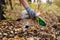 Close up of the female hand picking up bunch of trash from the forest floor