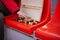 Close up of female hand put wooden chess pieces on red stadium bleacher. Concept of board game and leisure activity.