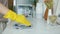 Close-up of female hand in rubber glove washing kitchen table with wet cloth doing housework in apartment