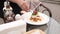 Close-up female hand serving appetizing pasta bolognese with cheese leaf greenery and vegetable