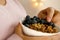 close-up female hand takes berries on blurred background with bokeh, healthy food white cup, oatmeal, blueberries, nuts, almonds,