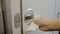 Close up female hand wiping aircraft lavatory door knob, cleaning habit, bacteria on airplane restroom door, corona virus covid19